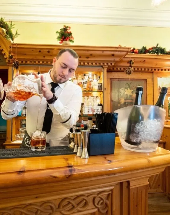 Barman prepara un cocktail al bancone del bar dell'hotel