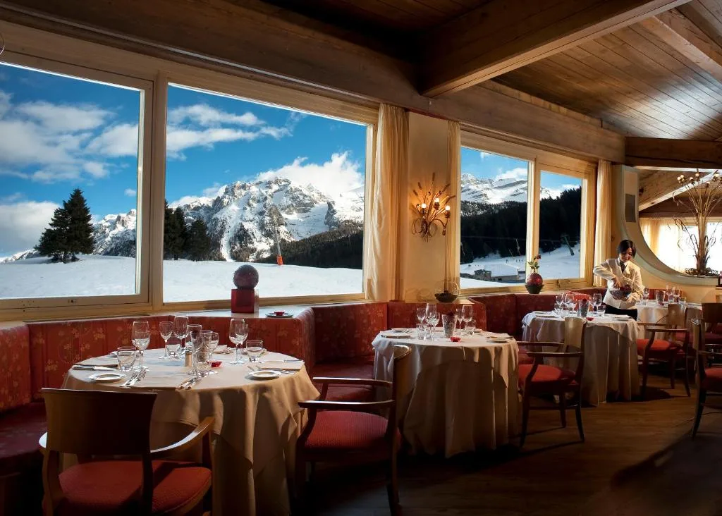 Sala ristorante con ampie vetrate panoramiche sulle Dolomiti innevate