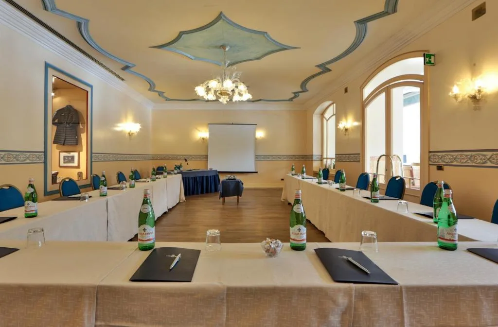 Sala conferenze con tavoli disposti a ferro di cavallo e lampadario