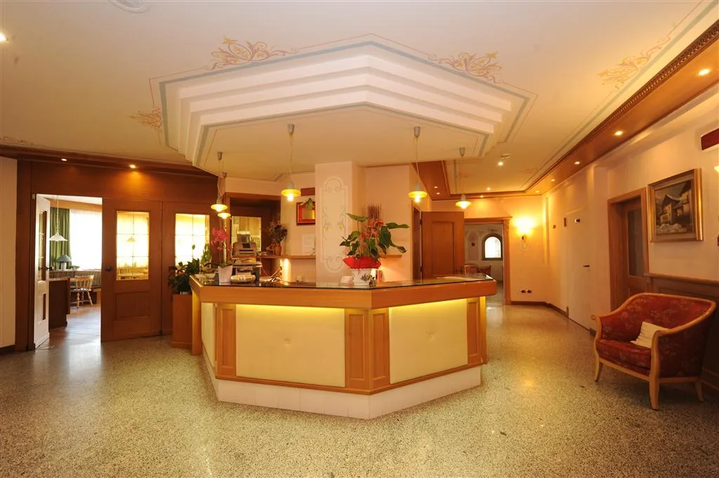 Reception dell'hotel con bancone in legno illuminato e soffitto decorato