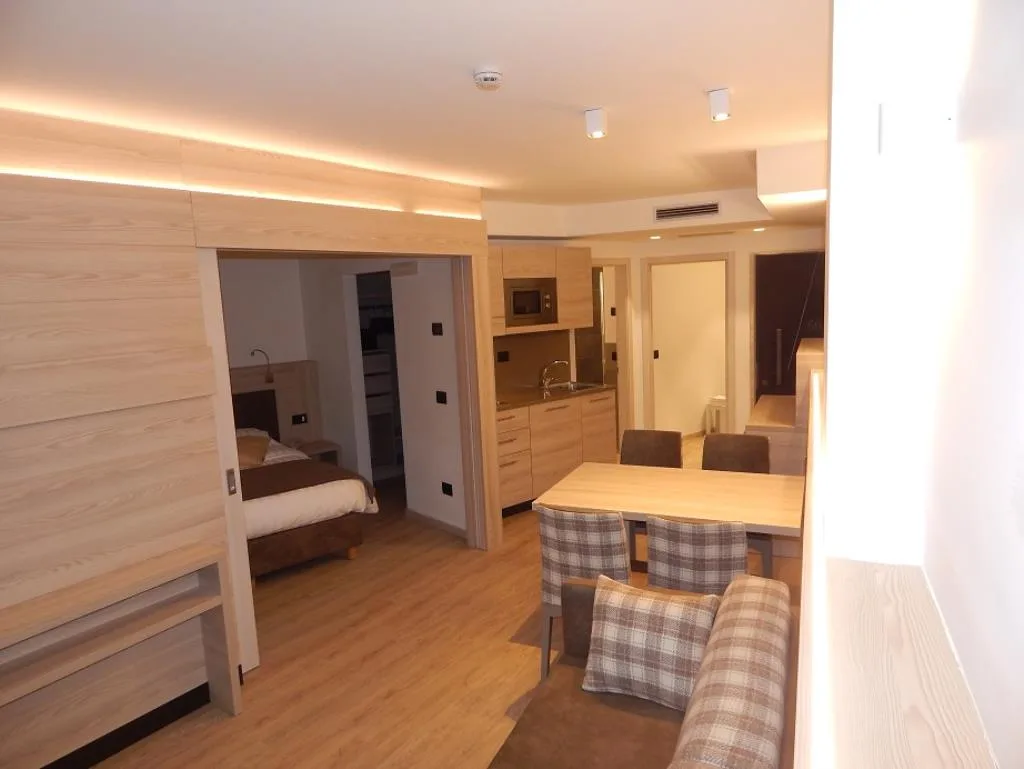 Interno di appartamento moderno con arredi in legno chiaro, tavolo e angolo cottura