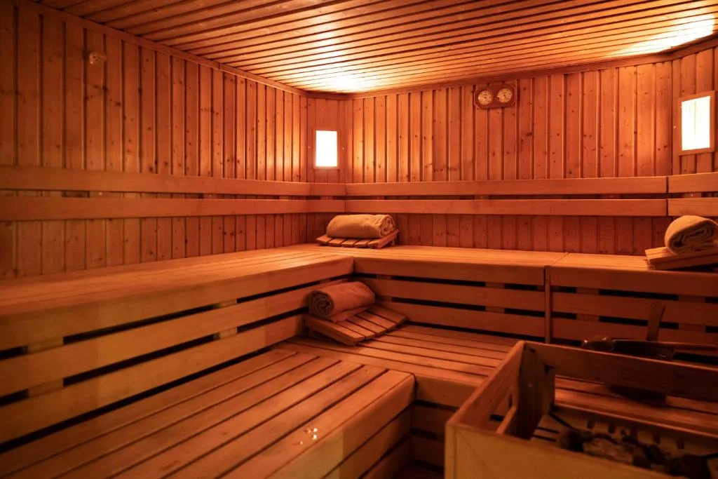 Sauna finlandese in legno con panche e asciugamani