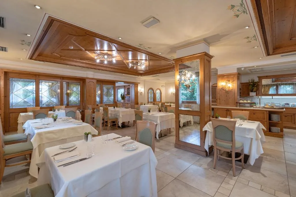 Sala ristorante elegante con tavoli apparecchiati e soffitto in legno
