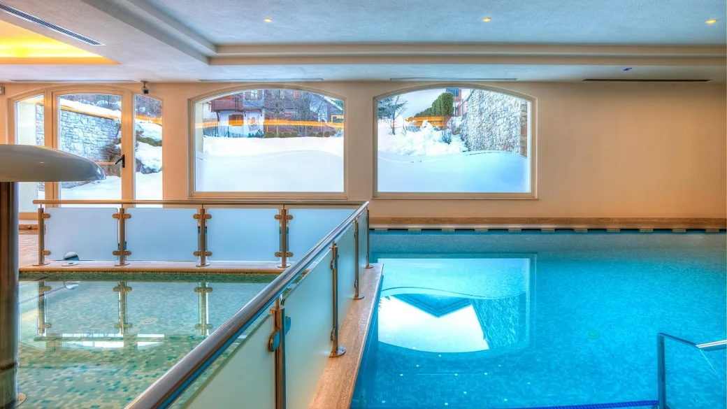 Piscina coperta con vista sulla neve attraverso le finestre