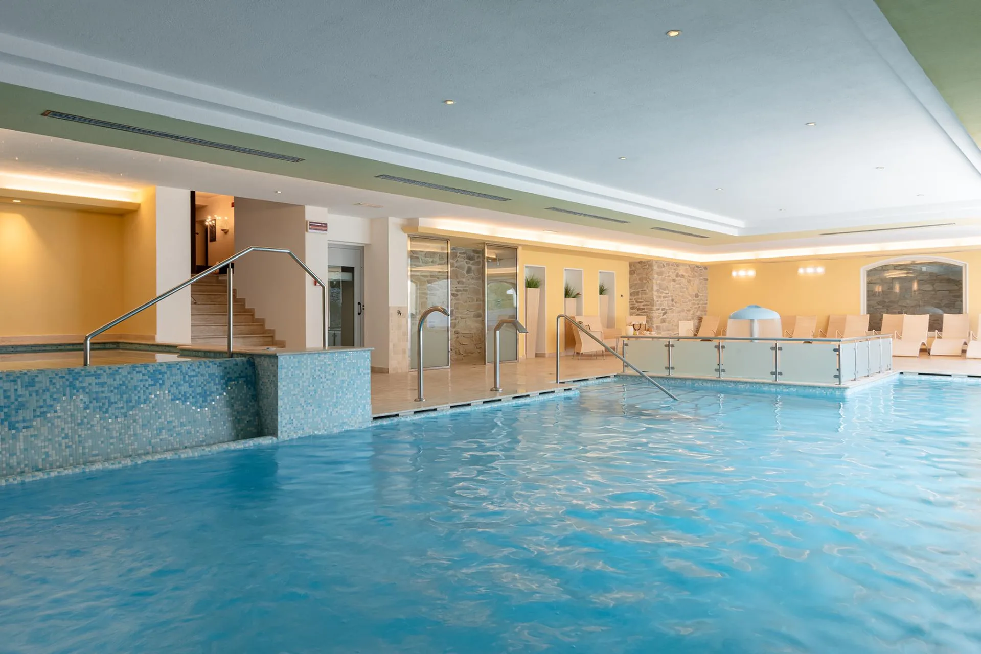 Piscina interna con vasca idromassaggio e lettini relax