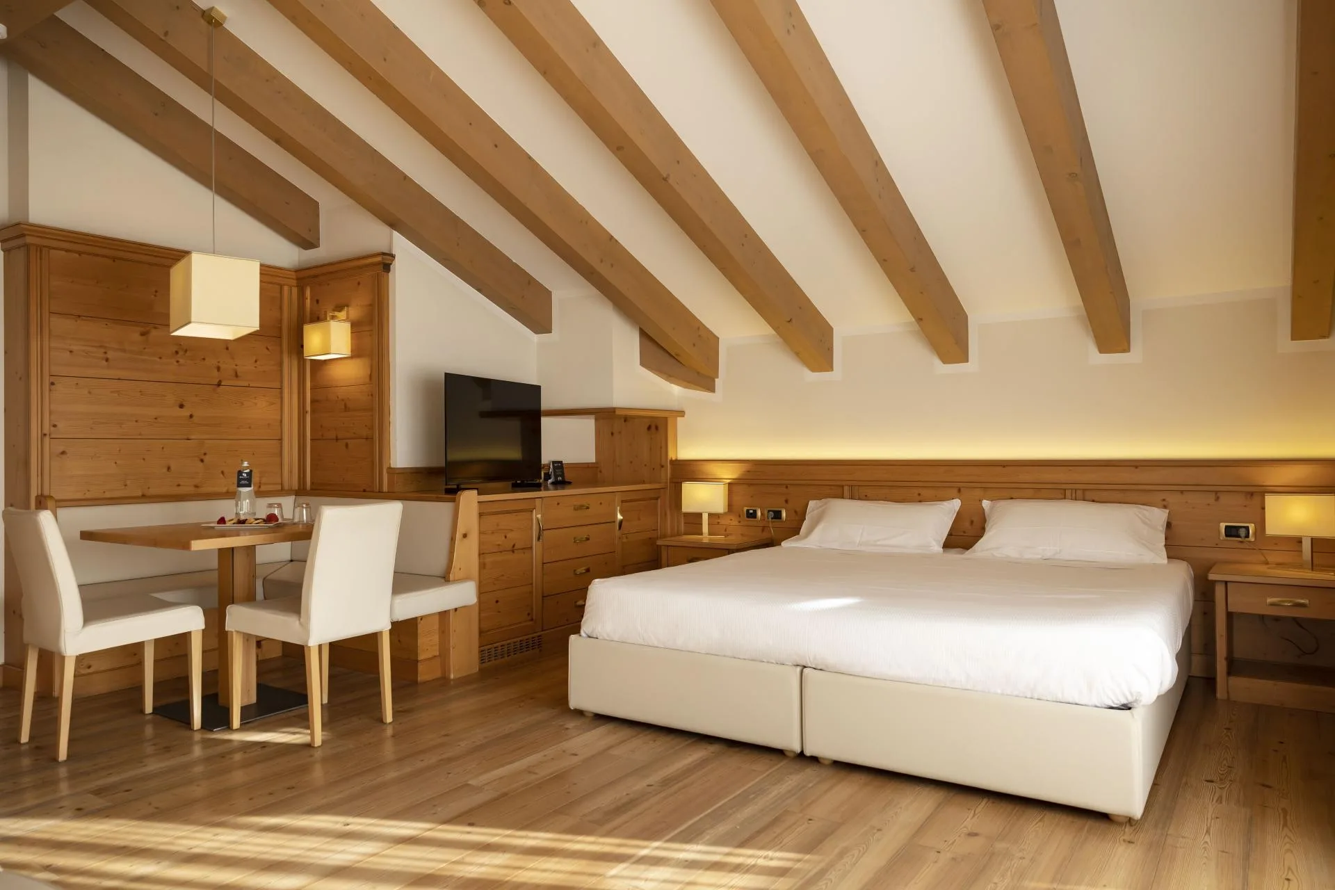 Camera mansardata luminosa con letto matrimoniale e angolo tavolo
