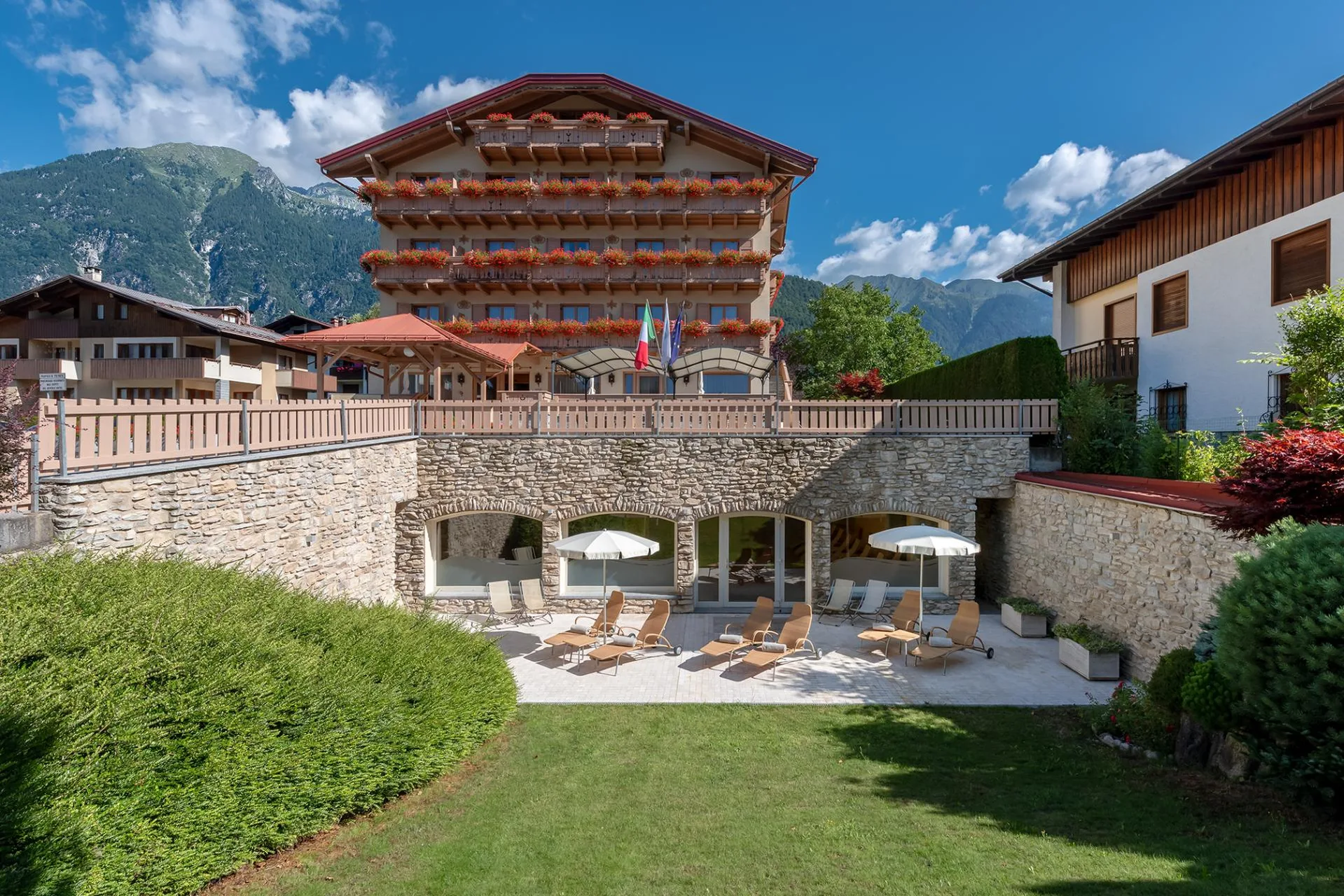 Terrazza e giardino dell'hotel con lettini e ombrelloni in estate