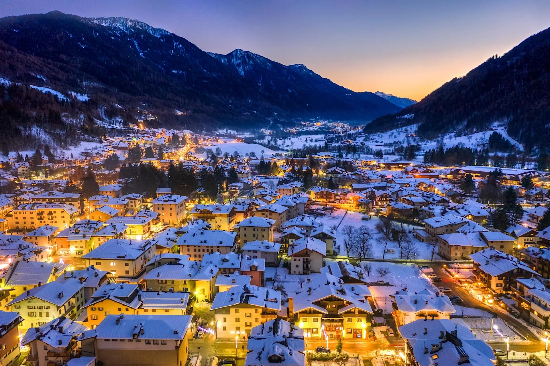 Vista aerea del paese di montagna illuminato al tramonto in inverno