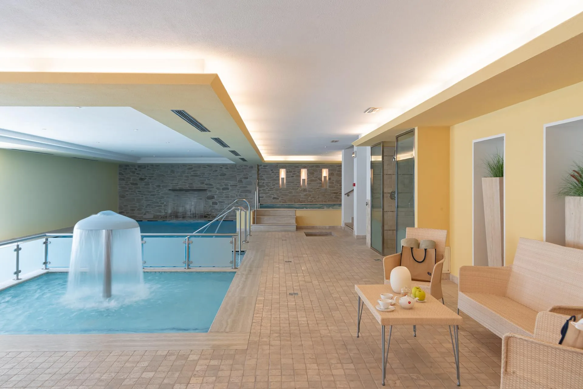 Piscina interna con fontana e zona relax con poltrone