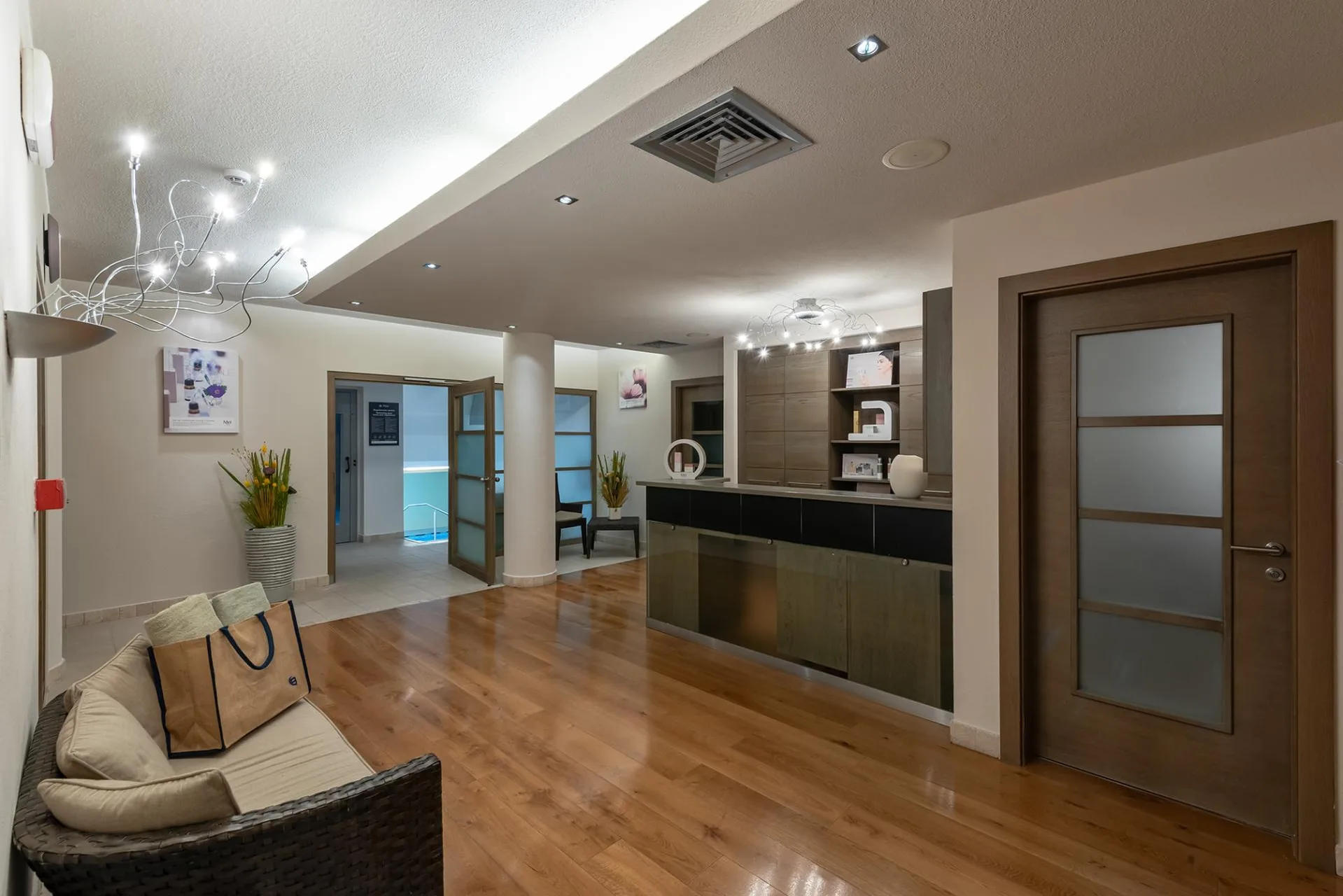 Reception della zona benessere con pavimento in legno e arredi moderni