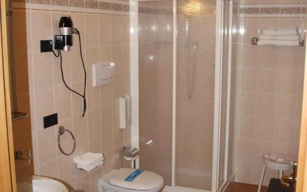 Bagno con doccia, wc, bidet e asciugacapelli a parete