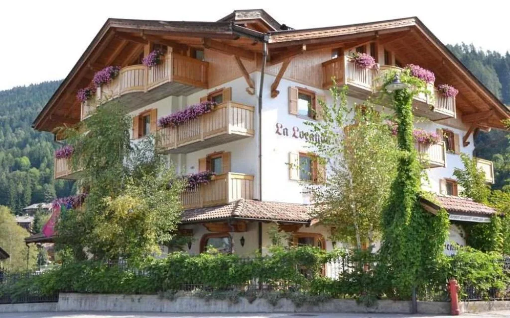 Esterno dell'Hotel La Locanda con balconi fioriti e vegetazione rampicante