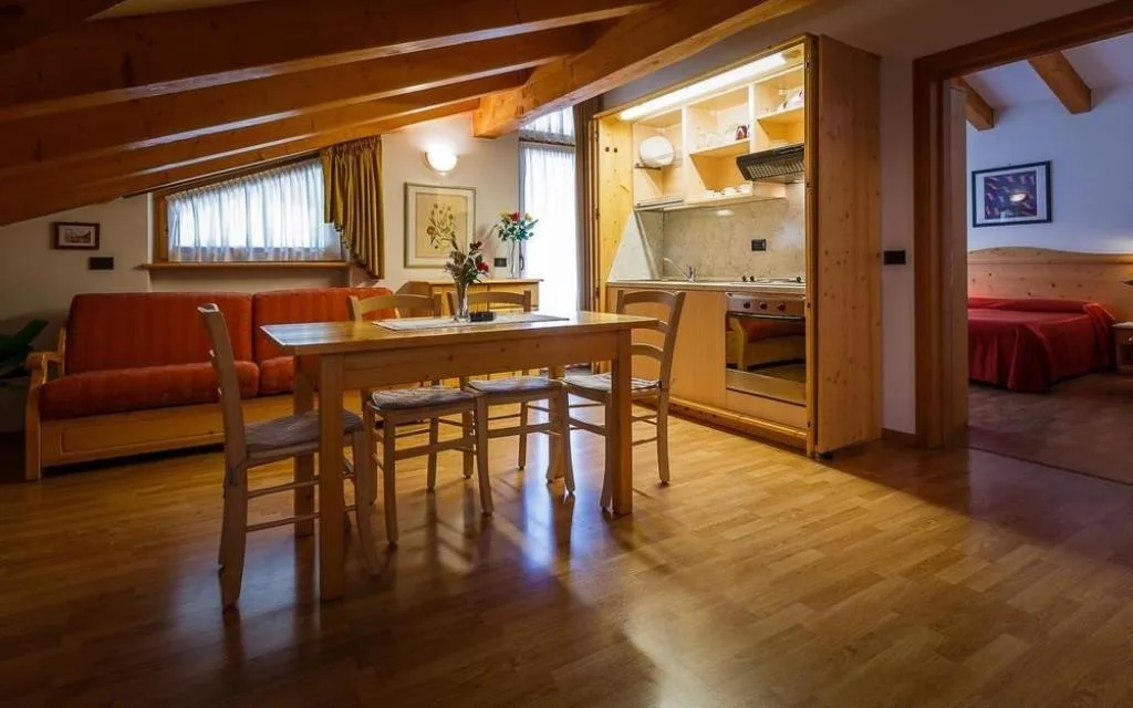 Appartamento mansardato con soggiorno, cucina e camera da letto sullo sfondo