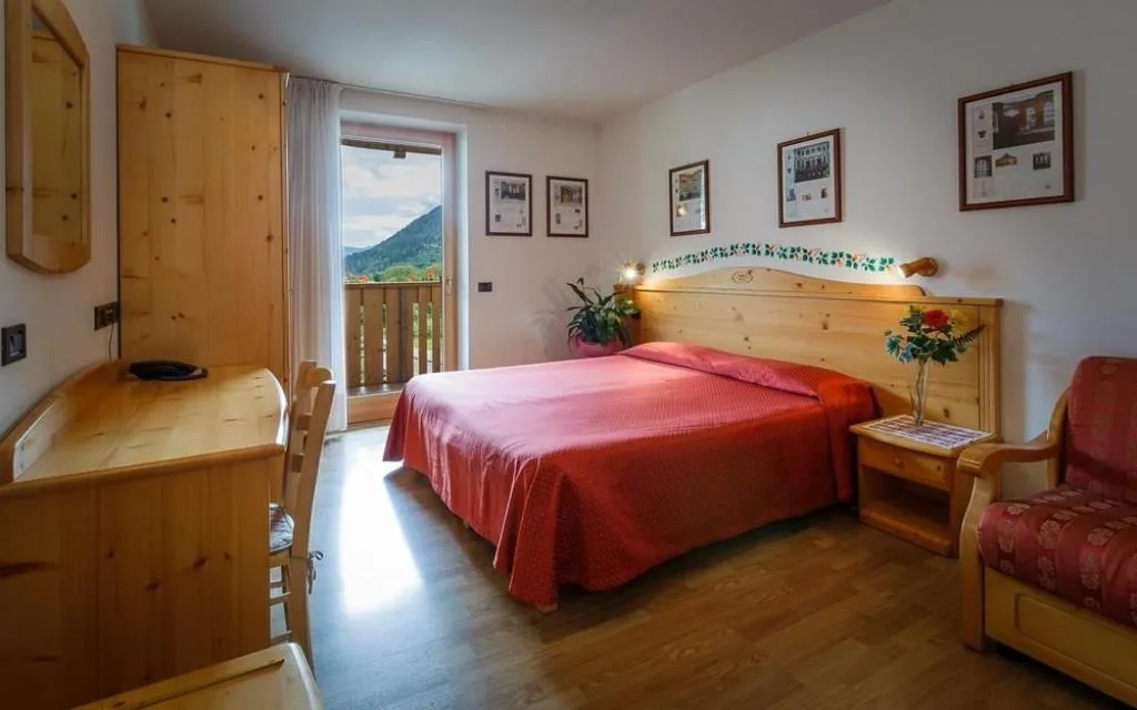 Camera matrimoniale con balcone e vista sulle montagne, arredi in legno